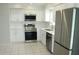 Contemporary kitchen with stainless steel appliances, white cabinets, and tile flooring at 6144 Elmhurst Dr, New Port Richey, FL 34653