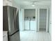 Laundry area featuring appliances, overhead light, bifold doors, and tile flooring at 6144 Elmhurst Dr, New Port Richey, FL 34653