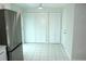 Laundry area featuring tile flooring, bifold closet doors, and a stainless steel refrigerator at 6144 Elmhurst Dr, New Port Richey, FL 34653