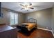Bedroom with wood floors, ceiling fan, and a large window that gives view to the yard at 616 Pawn Way, Seffner, FL 33584
