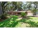 Inviting home exterior showcasing a lush lawn, mature landscaping, and stone facade, creating a welcoming curb appeal at 616 Pawn Way, Seffner, FL 33584