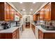 Charming galley kitchen with wood cabinets, tiled floor, and a view to the dining room at 616 Pawn Way, Seffner, FL 33584
