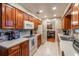 Functional kitchen featuring wood cabinets, white appliances, and tiled backsplash, offering a practical cooking space at 616 Pawn Way, Seffner, FL 33584