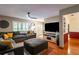 Bright living room boasts hardwood floors, a plush sofa, and plantation shutters, creating a cozy and inviting space at 616 Pawn Way, Seffner, FL 33584