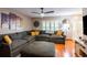 Relaxing living room with hardwood floors, a gray sectional sofa, and bright shutters, perfect for modern living at 616 Pawn Way, Seffner, FL 33584