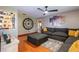 Cozy living room featuring a comfortable gray sofa, hardwood floors, and a decorative wall clock, perfect for relaxation at 616 Pawn Way, Seffner, FL 33584