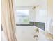 Bathroom showing tub and shower combination with tile and granite accents at 6250 Fairskies Dr, New Port Richey, FL 34655