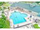 Aerial view of a large community pool surrounded by lounge chairs and umbrellas, perfect for relaxation at 6250 Fairskies Dr, New Port Richey, FL 34655