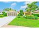 Charming home with a manicured lawn, lush landscaping, and a two-car garage at 6250 Fairskies Dr, New Port Richey, FL 34655