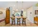 This is an angled view of the island with a sink, wooden countertop, three bar stools, and unique pendant lights at 6250 Fairskies Dr, New Port Richey, FL 34655