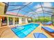 A screened-in pool area with lounge chairs and steps into the pool at 6250 Fairskies Dr, New Port Richey, FL 34655