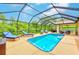 Bright, screened-in pool area with ample seating and a lovely view of the backyard foliage at 6250 Fairskies Dr, New Port Richey, FL 34655