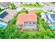 Aerial shot of a home with a screened-in pool and outdoor seating area, backing onto lush greenery at 6250 Fairskies Dr, New Port Richey, FL 34655