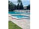 Community pool featuring a spa and poolside lounge chairs surrounded by lush greenery and a white picket fence at 6263 93Rd N Ter # 4202, Pinellas Park, FL 33782