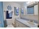 Coastal-themed bathroom with a vanity, sink, toilet, mirror, and nautical decorations at 6338 Newtown Cir # 38A6, Tampa, FL 33615