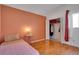 Bedroom with hardwood floors, accent wall, closet, and natural light from window at 6338 Newtown Cir # 38A6, Tampa, FL 33615