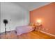 Simple bedroom with hardwood floors, light pink comforter, and accent wall at 6338 Newtown Cir # 38A6, Tampa, FL 33615