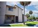 Condo exterior featuring a tan facade, green lawn and mature palm trees set against a blue sky with white clouds at 6338 Newtown Cir # 38A6, Tampa, FL 33615