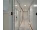 Bright hallway with mirrored closet doors, white tile flooring and recessed lighting at 6338 Newtown Cir # 38A6, Tampa, FL 33615