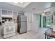 Kitchen with stainless steel refrigerator, white tile floors and a view to outdoor patio through sliding glass doors at 6338 Newtown Cir # 38A6, Tampa, FL 33615