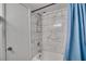Bathroom shower with marble-patterned tile surround and a shower curtain at 6338 Newtown Cir # 38A6, Tampa, FL 33615