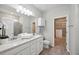 Elegant bathroom featuring double sinks, tile flooring, walk-in shower, and a closet at 6447 Bradford Woods Dr, Zephyrhills, FL 33542