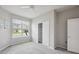 A bright bedroom with a ceiling fan, a closet with sliding doors, and a view from the window at 6447 Bradford Woods Dr, Zephyrhills, FL 33542