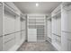 A spacious walk-in closet with custom shelving, drawers, and ample storage space for organization at 6447 Bradford Woods Dr, Zephyrhills, FL 33542
