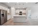 Modern kitchen features stainless steel appliances, granite countertops, and island with pendant lighting at 6447 Bradford Woods Dr, Zephyrhills, FL 33542
