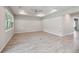 Bright living room with neutral paint, tray ceiling, ceiling fan, and a large window at 6447 Bradford Woods Dr, Zephyrhills, FL 33542