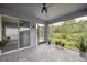 Spacious screened patio area with ceiling fan and sliding glass doors to yard at 6447 Bradford Woods Dr, Zephyrhills, FL 33542