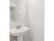 Pedestal sink in a minimalist bathroom with a round mirror, designed for space and style at 7001 Interbay Blvd # 203, Tampa, FL 33616
