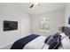 Bedroom featuring a TV, double door closet, and large window dressed with navy blue and gray bedding at 7001 Interbay Blvd # 203, Tampa, FL 33616