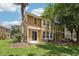 View of townhome exterior with stucco, windows, sliding glass doors, grass and trees on a sunny day at 7001 Interbay Blvd # 203, Tampa, FL 33616