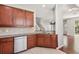Corner view of a kitchen featuring a stainless steel dishwasher, sink, and granite countertops with wood cabinets at 7001 Interbay Blvd # 203, Tampa, FL 33616
