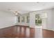 Spacious living room featuring gleaming wood floors, multiple windows, and sliding glass doors for ample natural light at 7001 Interbay Blvd # 203, Tampa, FL 33616