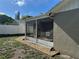 Here is an exterior view of a screened-in lanai along with a white privacy fence at 7301 Mitchell Ranch Rd, New Port Richey, FL 34655