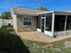 Exterior view of home showing a screened lanai with a stone perimeter and fenced backyard at 7301 Mitchell Ranch Rd, New Port Richey, FL 34655