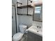 Bright bathroom features a modern vanity, wood shelves with black iron pipes, and a toilet at 7301 Mitchell Ranch Rd, New Port Richey, FL 34655