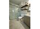Bathroom features a glass-enclosed shower, stylish wood vanity, and industrial-style shelving for modern appeal at 7301 Mitchell Ranch Rd, New Port Richey, FL 34655