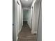 Hallway offers ample access to rooms in the home, featuring wood-look floors and neutral walls at 7301 Mitchell Ranch Rd, New Port Richey, FL 34655