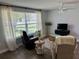 Living room showcases warm wood-look floors, stylish seating, and a large window for plenty of sunlight at 7301 Mitchell Ranch Rd, New Port Richey, FL 34655