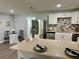 Open-concept living space with kitchen island and stainless steel appliances at 7301 Mitchell Ranch Rd, New Port Richey, FL 34655