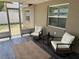 Relaxing screened patio features tile floors, two chairs, and a small table at 7301 Mitchell Ranch Rd, New Port Richey, FL 34655