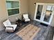 Relaxing screened patio features tile floors, two chairs, and a small table at 7301 Mitchell Ranch Rd, New Port Richey, FL 34655
