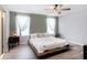 Spacious bedroom with wood floors, ceiling fan, and bright windows draped with flowing sheer curtains at 7405 French Marigold Ave, Tampa, FL 33619