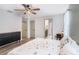 Well-lit bedroom with wood flooring, ceiling fan, dresser, and glimpses of the adjacent bathroom at 7405 French Marigold Ave, Tampa, FL 33619