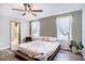 Bright bedroom showcasing a ceiling fan, decorative windows, and wood floors leading to the en suite at 7405 French Marigold Ave, Tampa, FL 33619