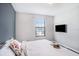 Bright bedroom with a large window, neutral color scheme, and comfortable queen-sized bed at 7405 French Marigold Ave, Tampa, FL 33619