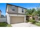 Charming home exterior featuring a two-car garage and manicured lawn under a sunny blue sky at 7405 French Marigold Ave, Tampa, FL 33619